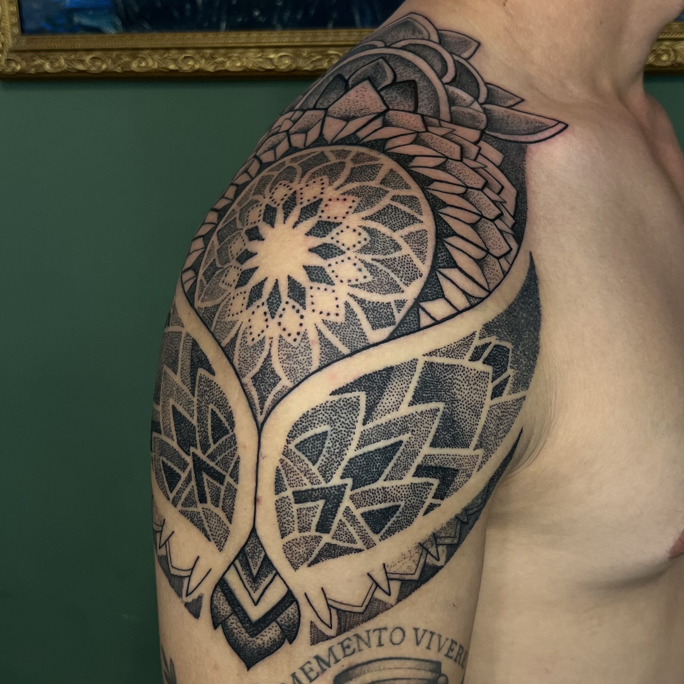 TATUAGEM DE UMA MANDALA EM PONTILHISMO NO OMBRO DE UM HOMEM
